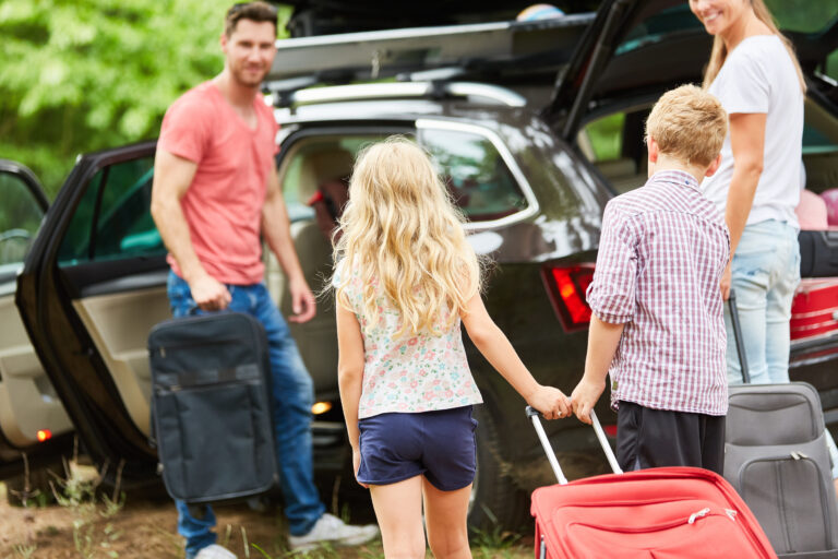 familie am auto beim koffer packen